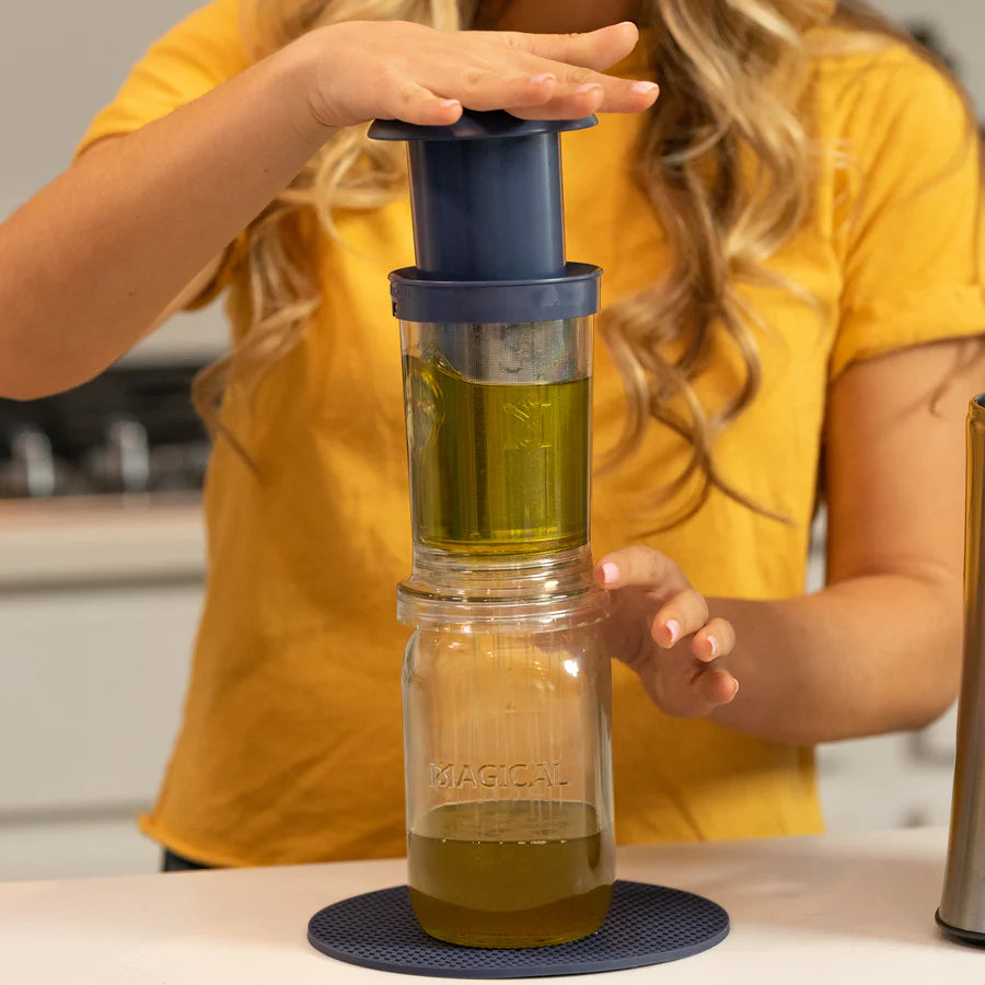 Magical Filter Press straining infused oil into a jar